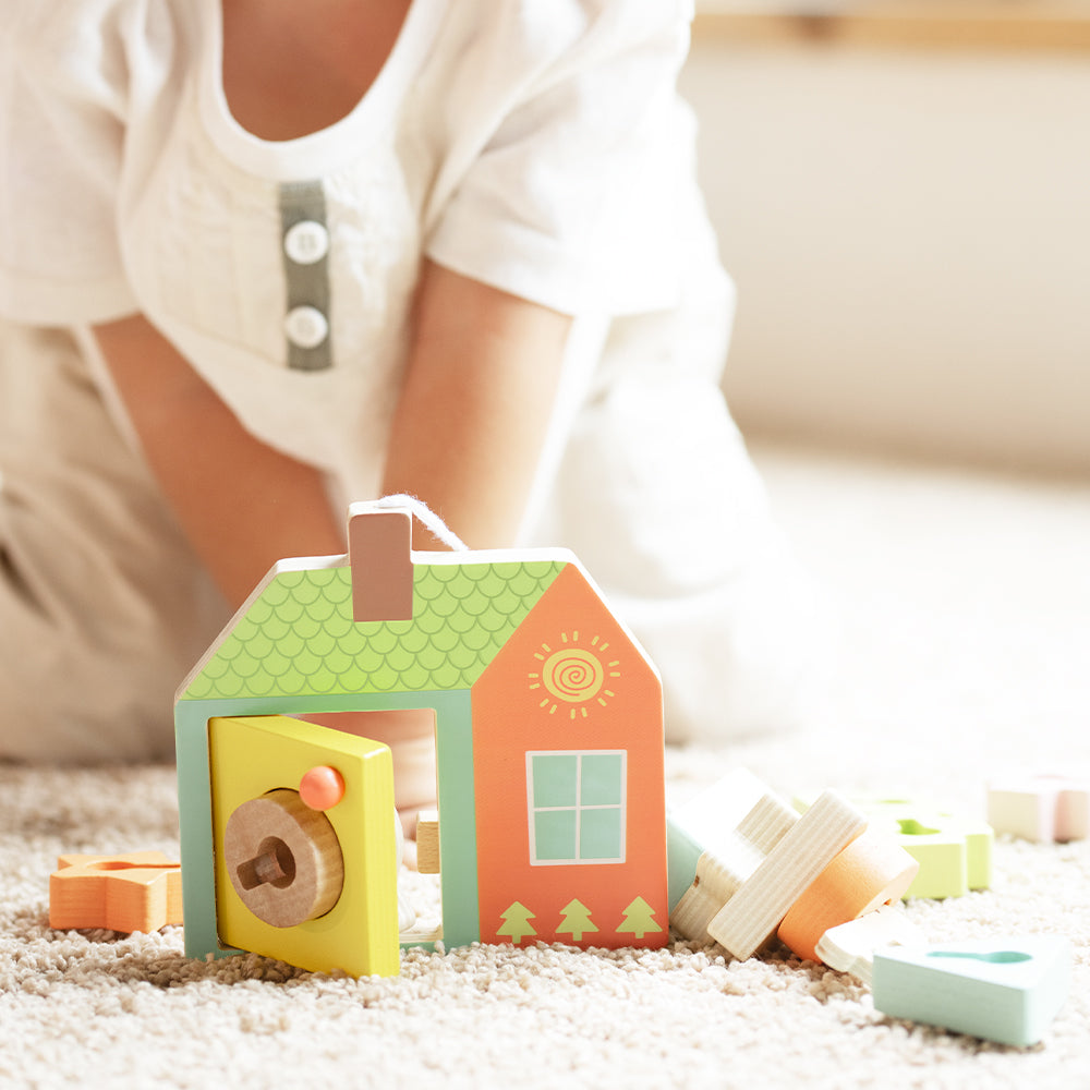 Drewniana zabawka Sensoryczna Przeplatanka z kluczami i drzwiami Montessori, zestaw 11 elementów, w tym klocki w różnych kształtach i kolorach, drewniany domek z otworami, klucz do nawlekania, wzory układanek.