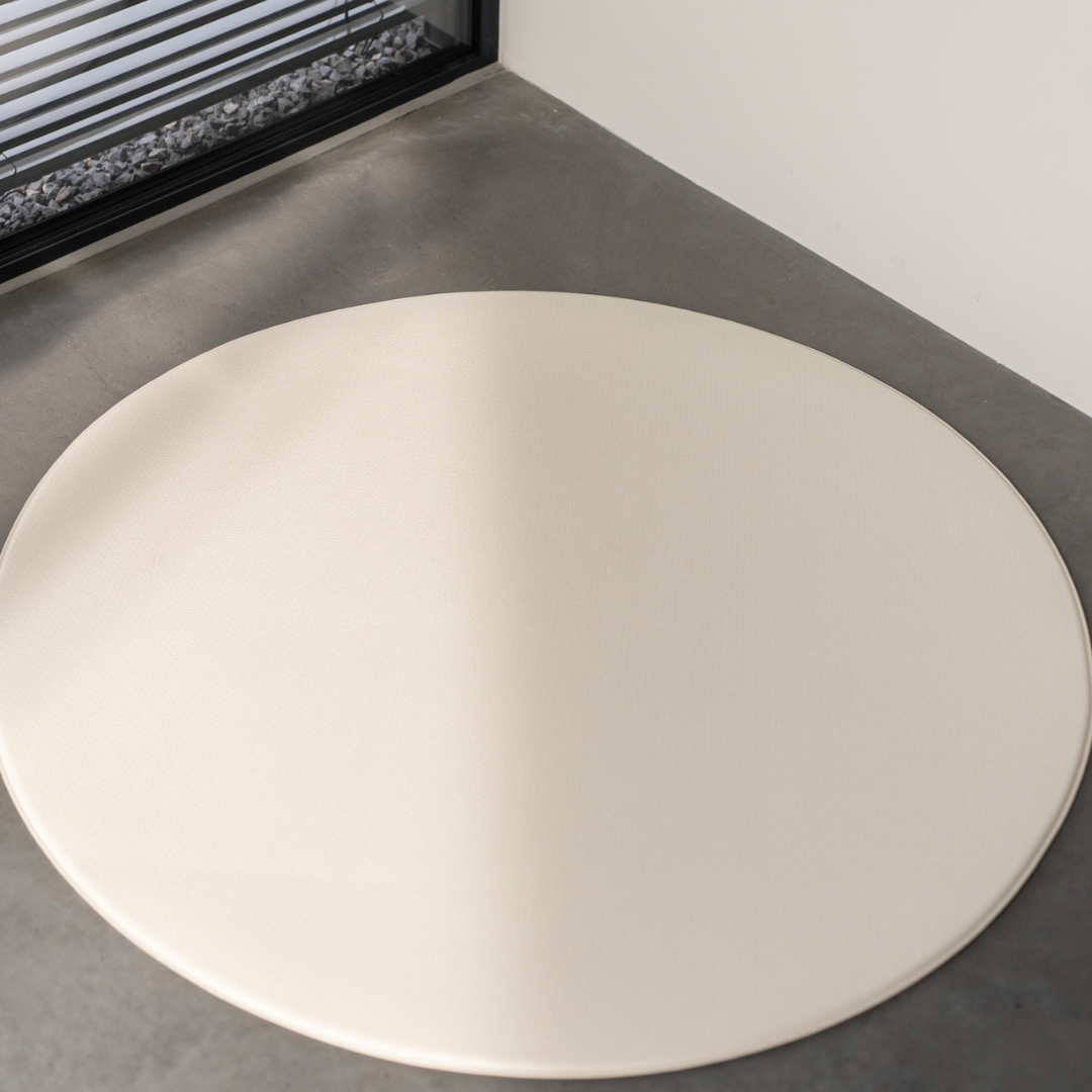 Dziecko siedzące na dwustronnej macie do zabawy marki Dwinguler w jasnym wnętrzu. Mata posiada delikatny wzór, zapewniając bezpieczną i komfortową przestrzeń do raczkowania i zabawy.