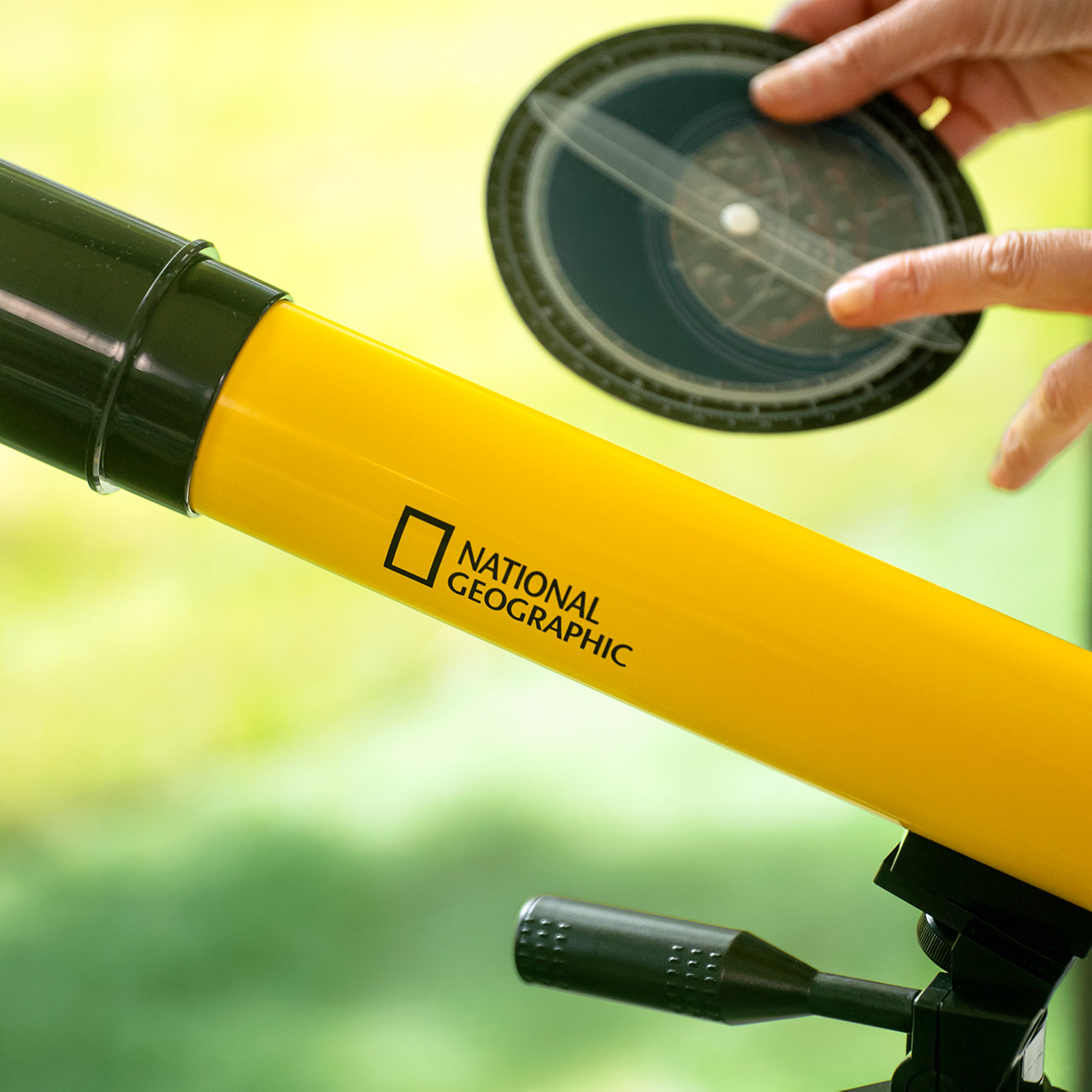 Teleskop Bresser 45/600 mm z rodziny National Geographic, w kolorze żółtym, umieszczony na statywie, przeznaczony do obserwacji astronomicznych, z lunetką celowniczą, różnymi okularami do zmiany powiększenia oraz możliwością użycia do obserwacji przyrody, idealny dla dzieci od 7 roku życia.