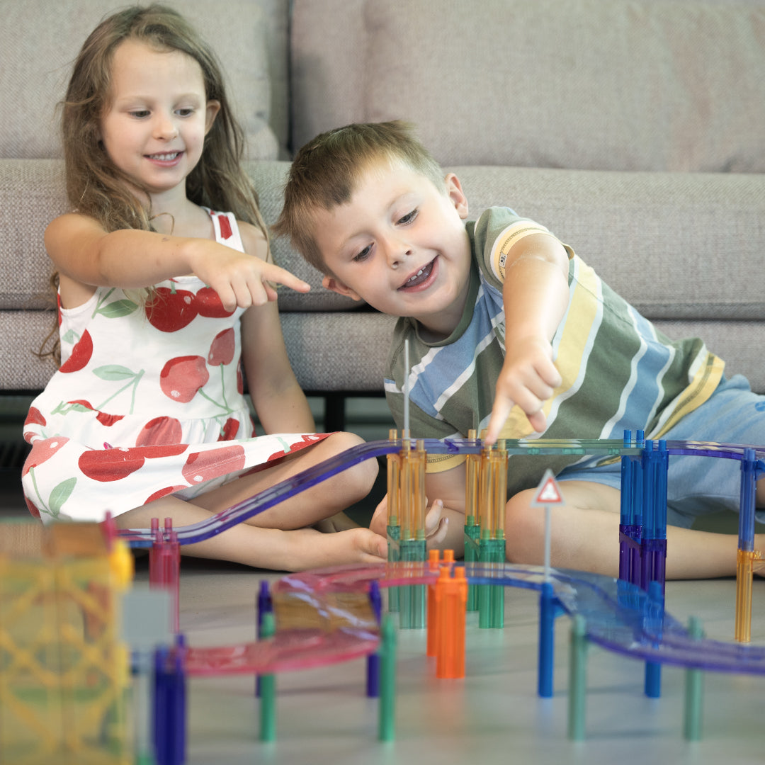 Klocki magnetyczne Cleverclixx Large Race Track Pastel składają się z 80 elementów, w tym dwóch samochodów (zielonego i fioletowego), 10 ramp, 12 płytek w kształcie łuku, 12 znaków drogowych, 10 płytek kwadratowych, 22 filarów oraz 12 płytek prostokątnych. Zestaw umożliwia budowanie różnorodnych torów wyścigowych i dodatkowych konstrukcji, co rozwija zdolności manualne, logiczne myślenie oraz kreatywność dzieci.