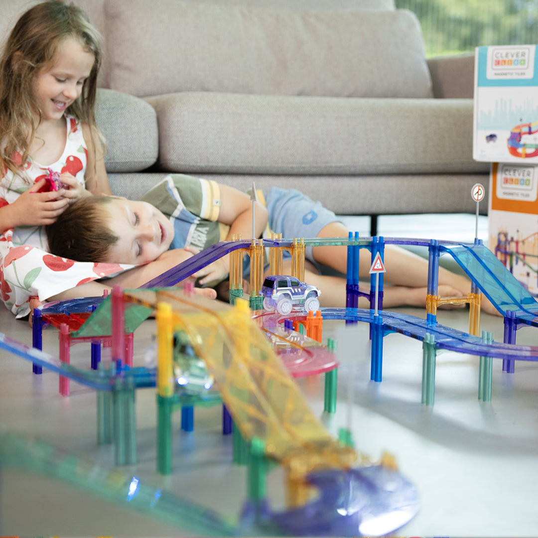 Klocki magnetyczne Cleverclixx Large Race Track Pastel składają się z 80 elementów, w tym dwóch samochodów (zielonego i fioletowego), 10 ramp, 12 płytek w kształcie łuku, 12 znaków drogowych, 10 płytek kwadratowych, 22 filarów oraz 12 płytek prostokątnych. Zestaw umożliwia budowanie różnorodnych torów wyścigowych i dodatkowych konstrukcji, co rozwija zdolności manualne, logiczne myślenie oraz kreatywność dzieci.