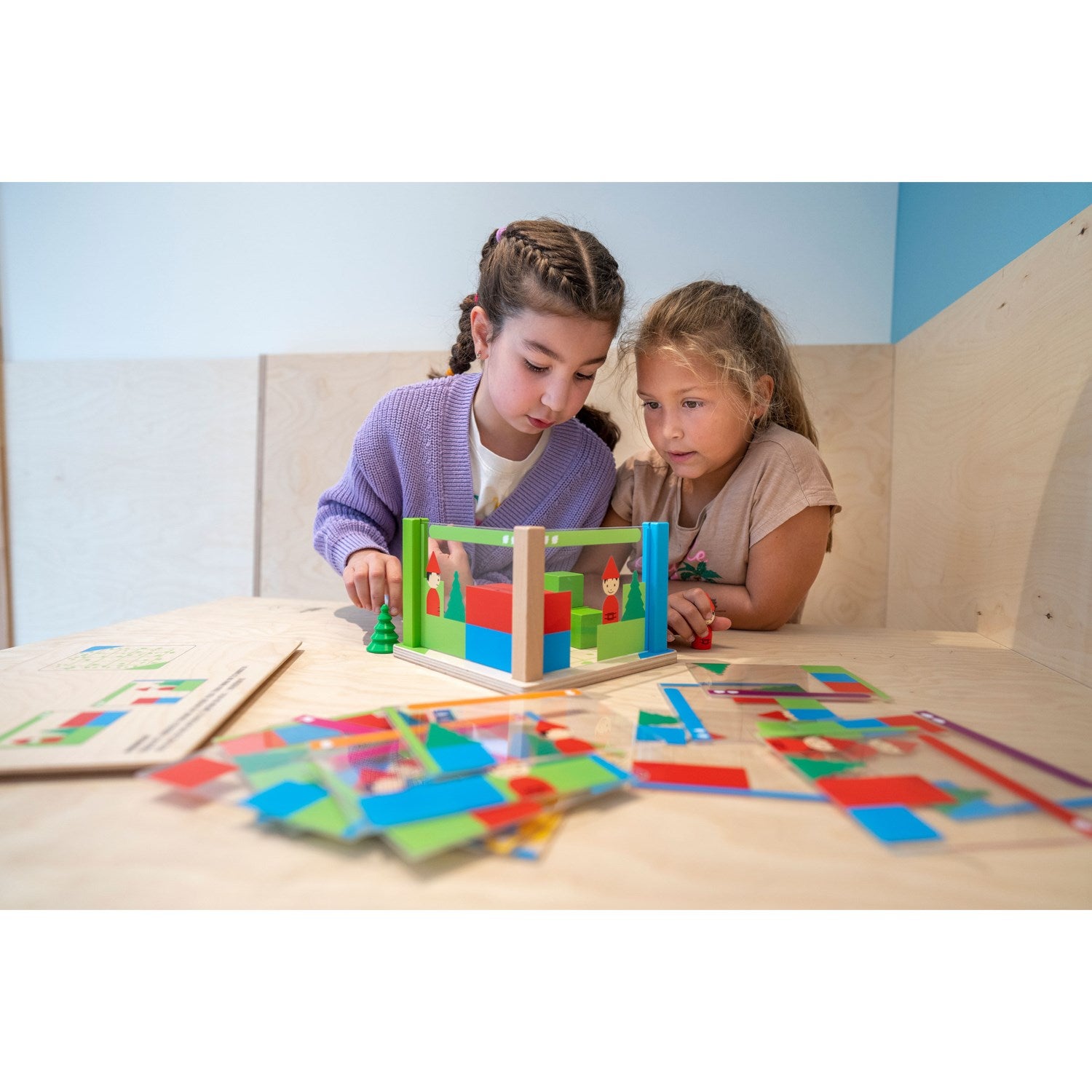 Dziecko buduje konstrukcję z klocków Montessori Educo i porównuje ją z kartą perspektyw – nauka widzenia z różnych stron