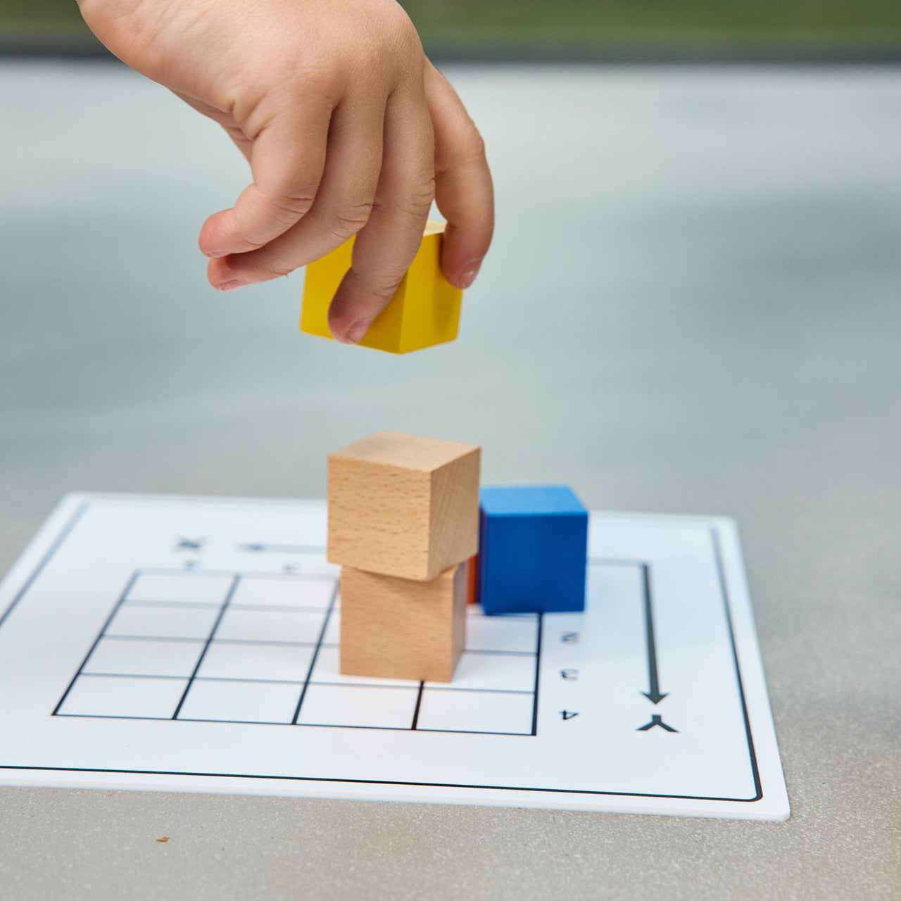 Budowanie przestrzenne BUILD XYZ Montessori – dziecko układa kolorowe klocki Educo według karty z zadaniem 3D