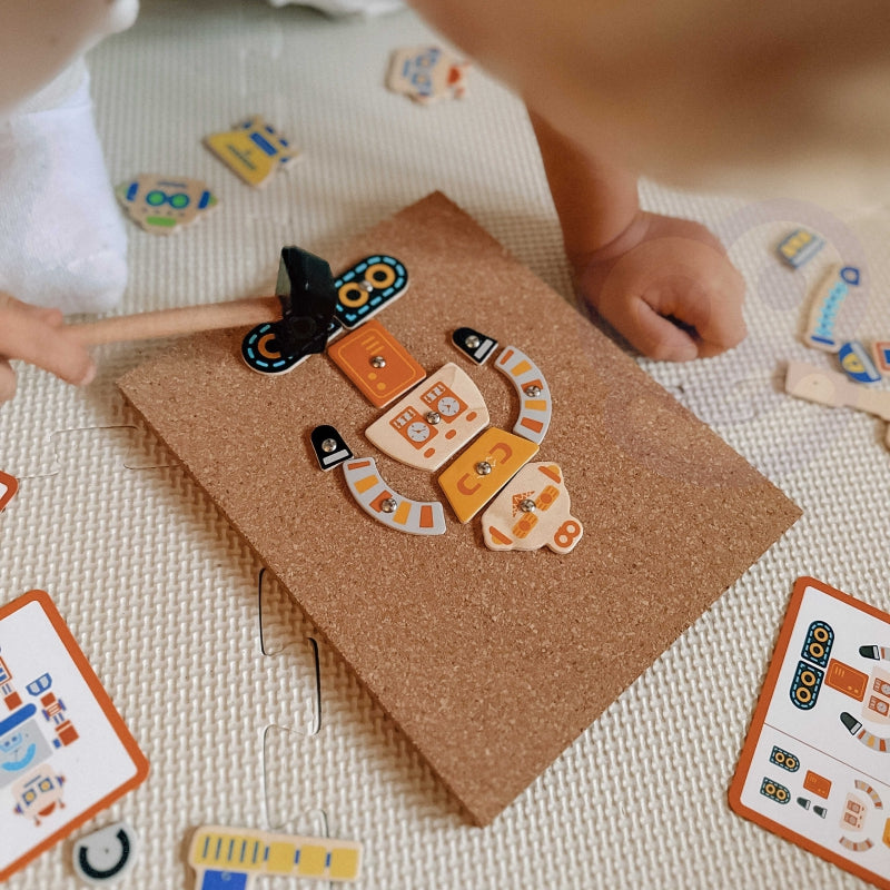 Dziecko przybija robota młoteczkiem na tablicy korkowej VIGA Montessori – trening precyzji i koordynacji ręka-oko