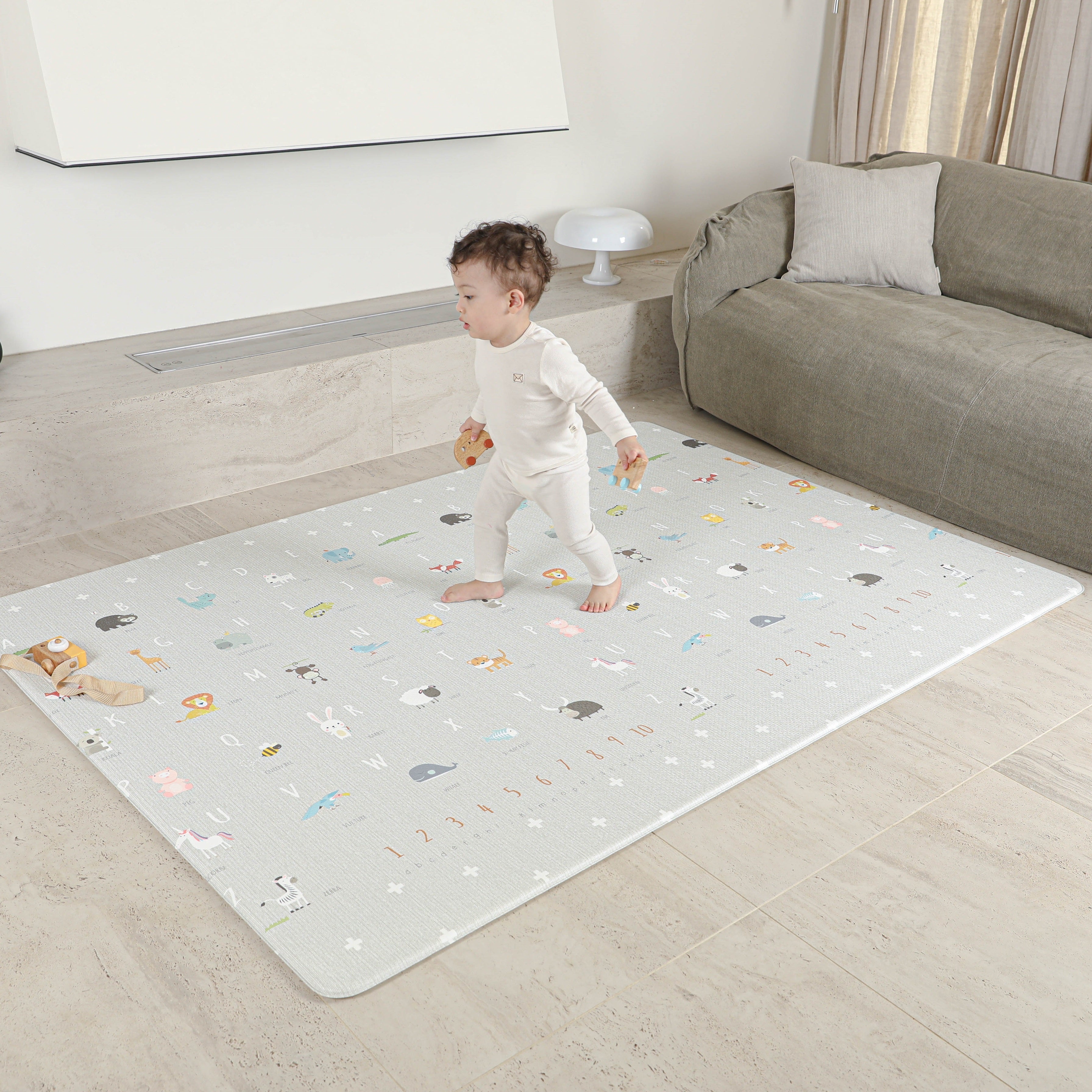 Dziecko stojące na macie piankowej Dwinguler Soft Animals M – bezpieczna, certyfikowana mata do raczkowania i zabawy