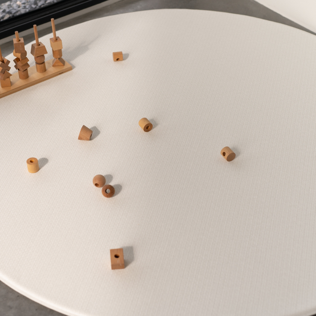 Ddwustronna mata do zabawy marki Dwinguler w jasnym wnętrzu. Mata posiada delikatny wzór, zapewniając bezpieczną i komfortową przestrzeń do raczkowania i zabawy.