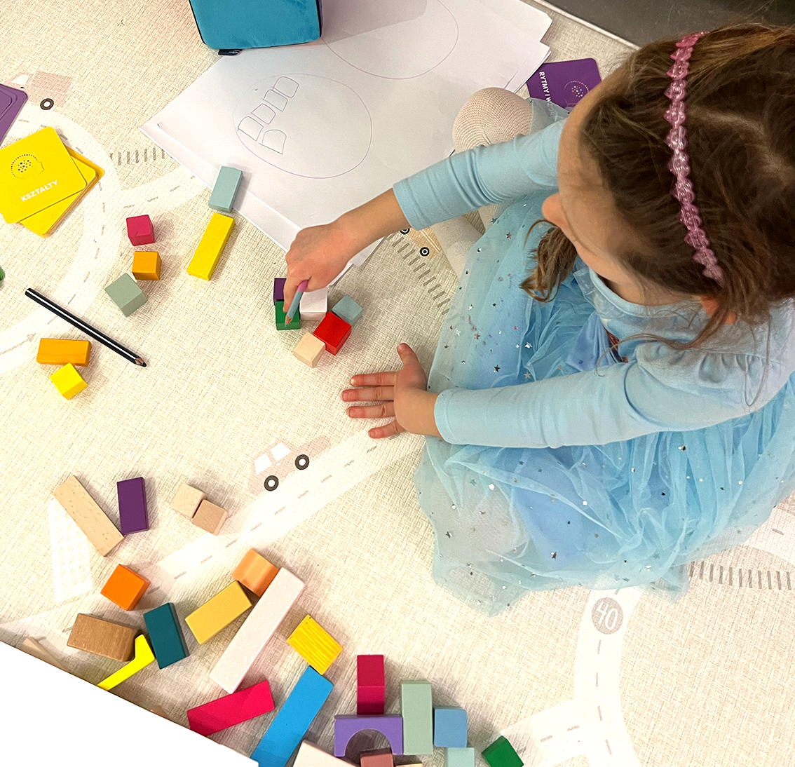 Nauka liczenia z kartami matematycznymi i klockami – dziecko wykonuje zadanie z karty Matematyka przez Zabawę