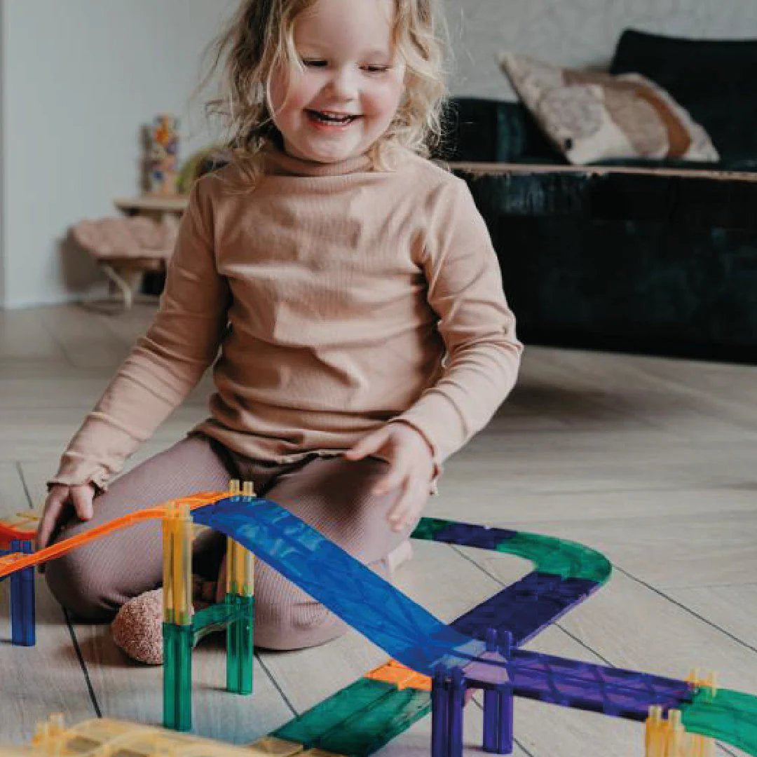 Zestaw Cleverclixx Samochodowy Tor Wyścigowy Intense składa się z 65 elementów, w tym samochodu, ramp, giętych płytek, znaków drogowych oraz filarów, które umożliwiają dzieciom budowanie różnorodnych torów wyścigowych, tuneli i mostów, wspierając rozwój zdolności manualnych, koncentracji i logicznego myślenia. Klocki są wykonane z trwałego plastiku MABS, wolnego od BPA, co zapewnia bezpieczeństwo w trakcie zabawy. Zestaw jest odpowiedni dla dzieci powyżej 3 roku życia.