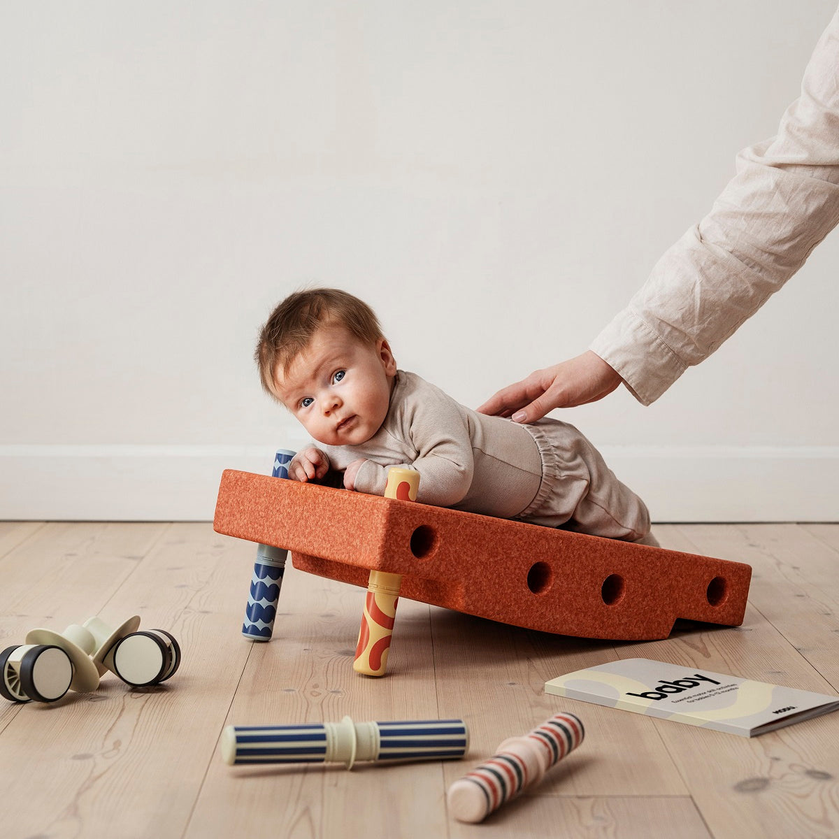 Zestaw MODU - Baby Activity Set to innowacyjna zabawka wspierająca rozwój dzieci w pierwszym roku życia. Zawiera sensoryczny blok piankowy, na którym maluch może się położyć, chwiać, przechylać i kołysać, oraz cztery kolorowe grzechotki z interesującymi wzorami i dźwiękami, stymulujące rozwój sensoryczny. Do zestawu dołączony jest Przewodnik Aktywności z 12 ćwiczeniami, które pomagają rodzicom wspierać kluczowe etapy rozwoju motorycznego dziecka.