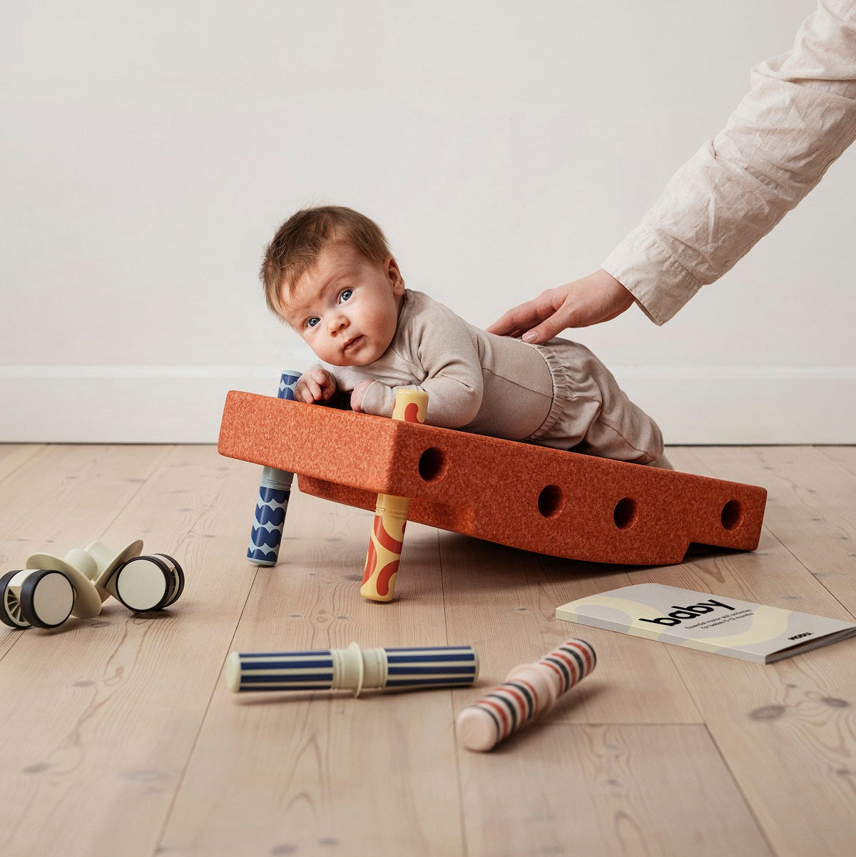Zestaw MODU - Baby Activity Set to innowacyjna zabawka wspierająca rozwój dzieci w pierwszym roku życia. Zawiera sensoryczny blok piankowy, na którym maluch może się położyć, chwiać, przechylać i kołysać, oraz cztery kolorowe grzechotki z interesującymi wzorami i dźwiękami, stymulujące rozwój sensoryczny. Do zestawu dołączony jest Przewodnik Aktywności z 12 ćwiczeniami, które pomagają rodzicom wspierać kluczowe etapy rozwoju motorycznego dziecka.