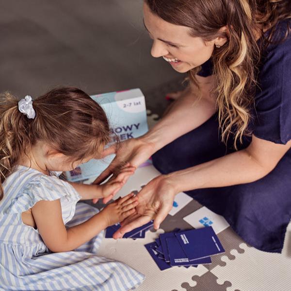 Zdjęcie przedstawia kobietę i dziewczynkę grające w grę "Rozwojowy sorterek".