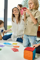 Na zdjęciu kobieta i troje dzieci grających w grę "Kostka aktywności". Chłopiec odczytuje zadanie z karty