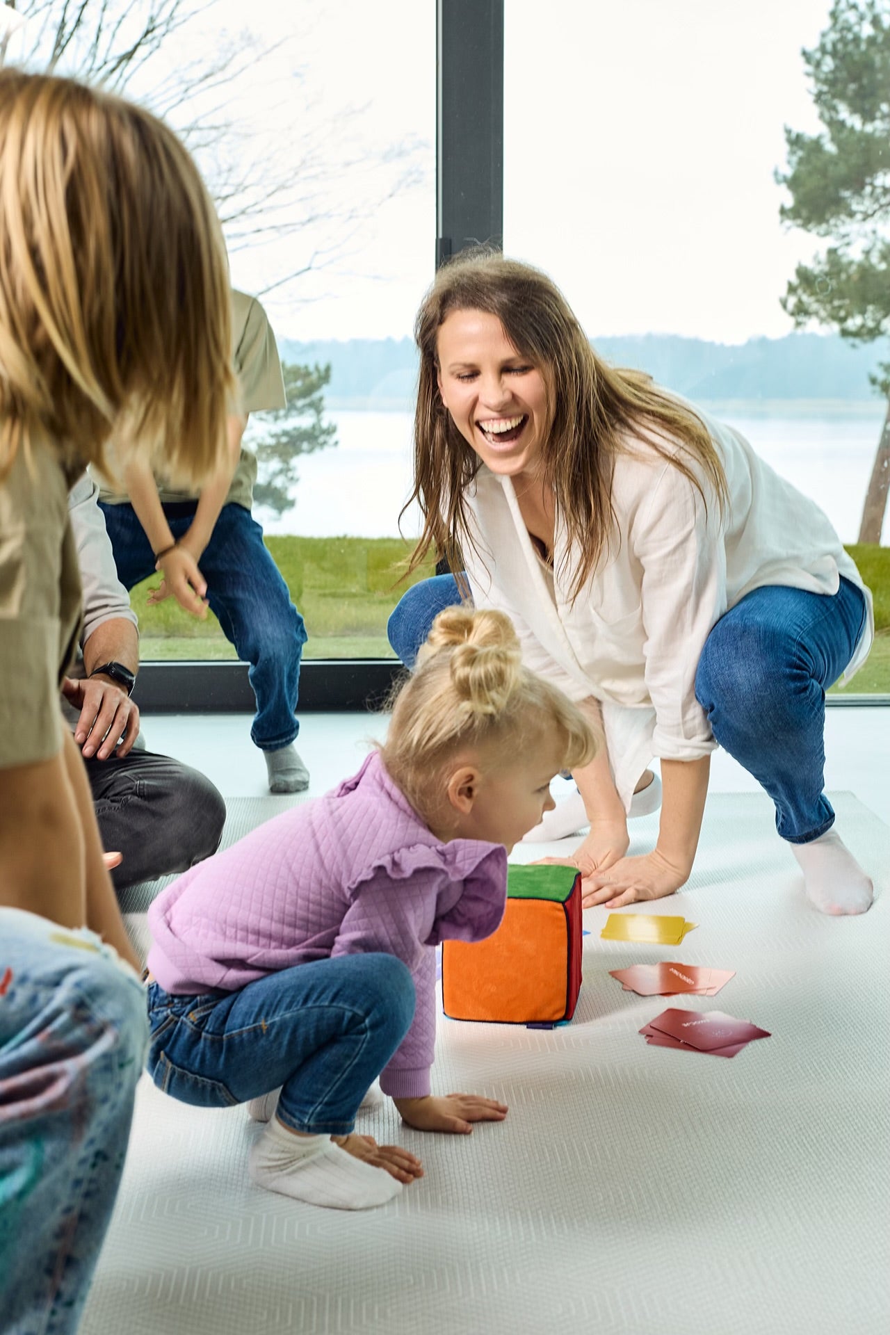 Na zdjęciu kobieta i troje dzieci grających w grę "Kostka aktywności"