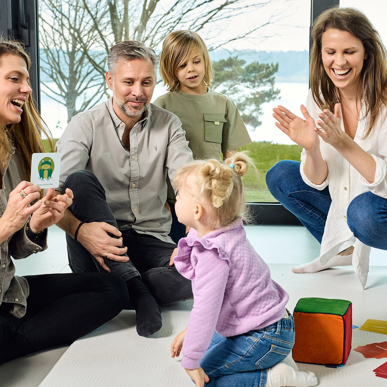 Na zdjęciu widoczna grupa dorosłych i dzieci grających w grę "Kostka aktywności - nauka przez zabawę"