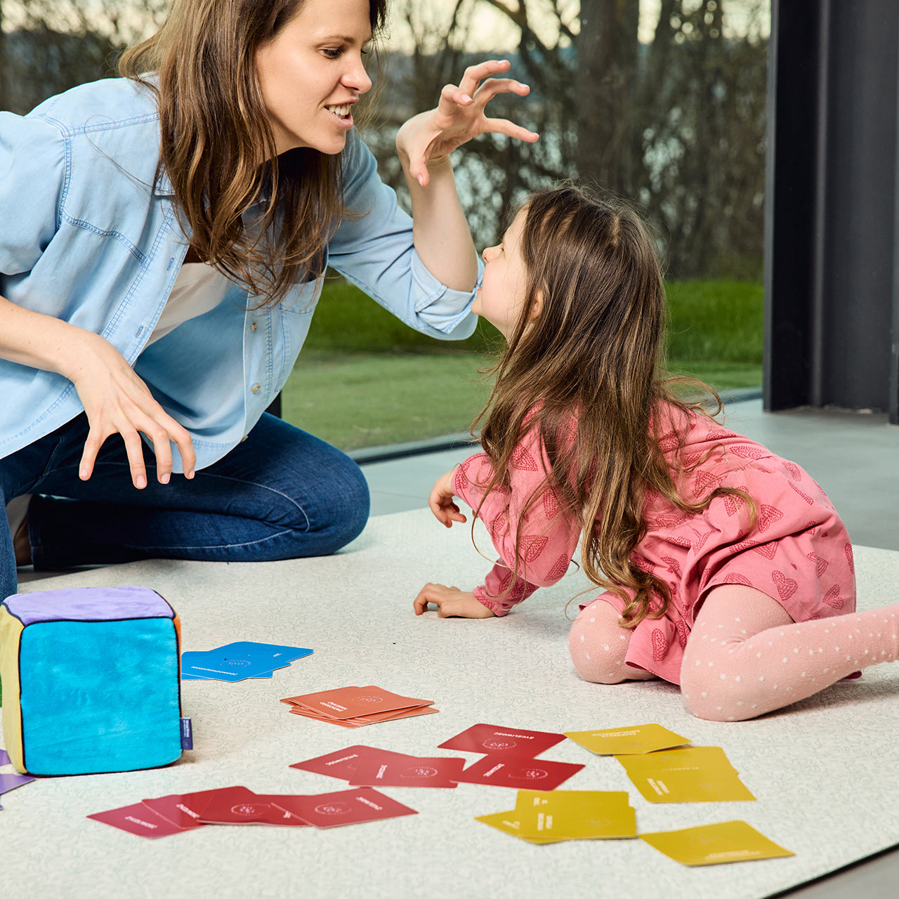 Na zdjęciu kobieta i dziewczynka grające w grę "Kostka aktywności - mindfulness"