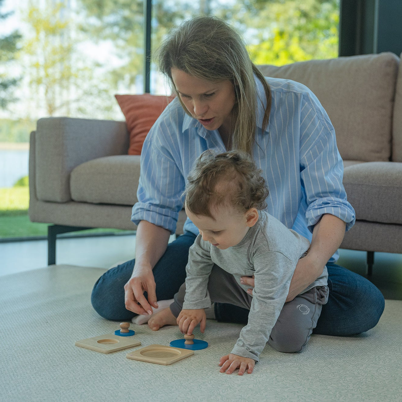 Zabawa Montessori z puzzlami kształtów – dziecko skupione na dopasowywaniu figur geometrycznych, trening koncentracji