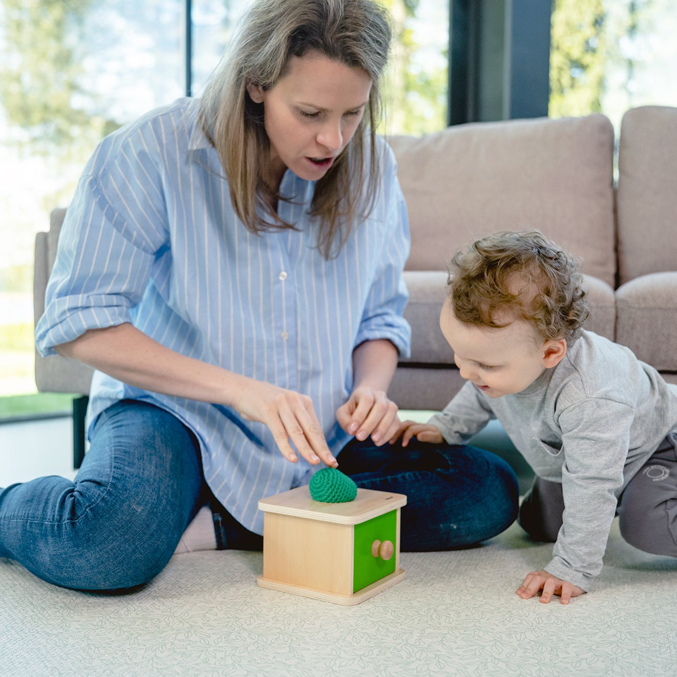 Dziecko wrzuca miękką piłeczkę do otworu szufladki Montessori Educo – trening koordynacji ręka-oko i chwytu