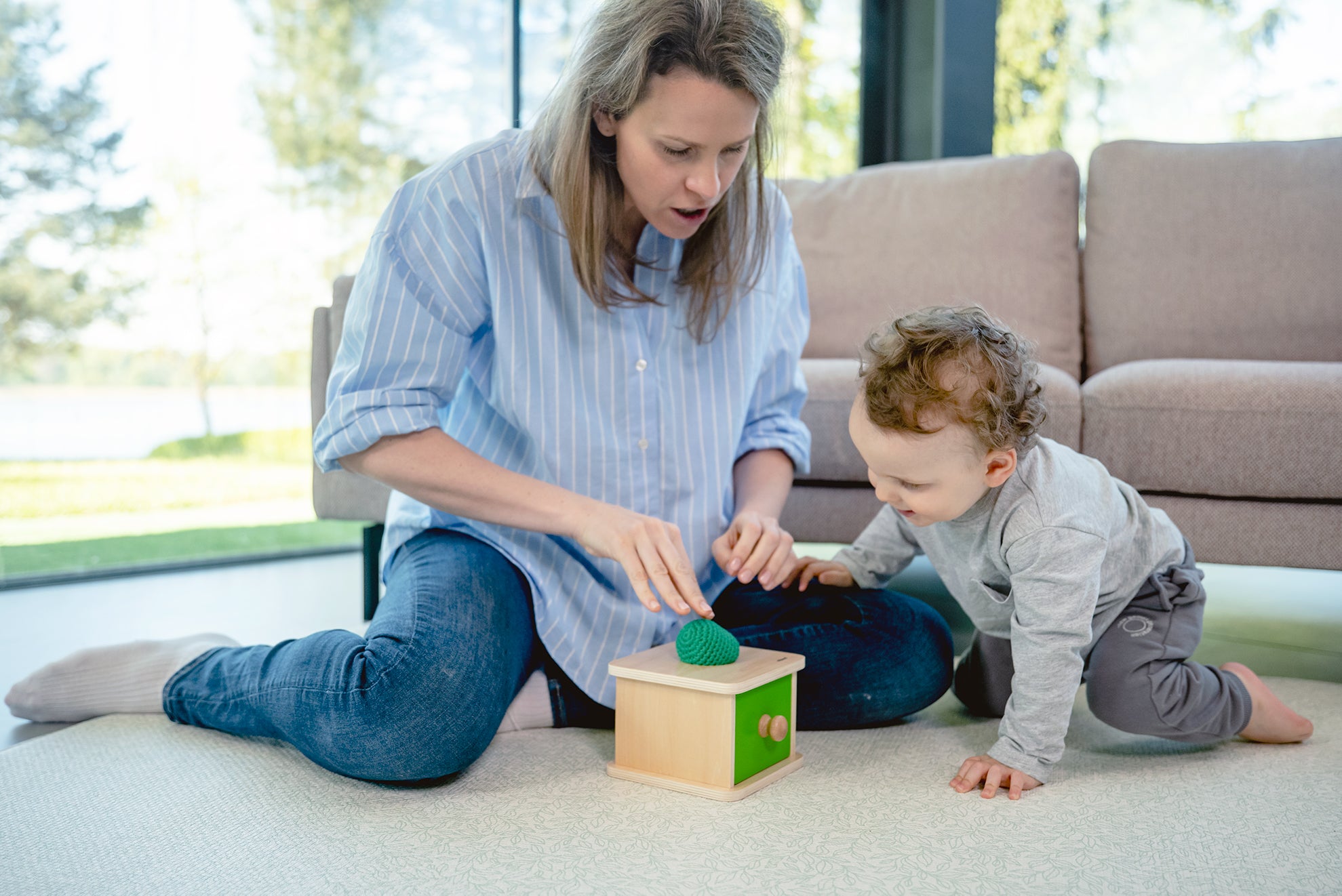Dziecko wrzuca miękką piłeczkę do otworu szufladki Montessori Educo – trening koordynacji ręka-oko i chwytu
