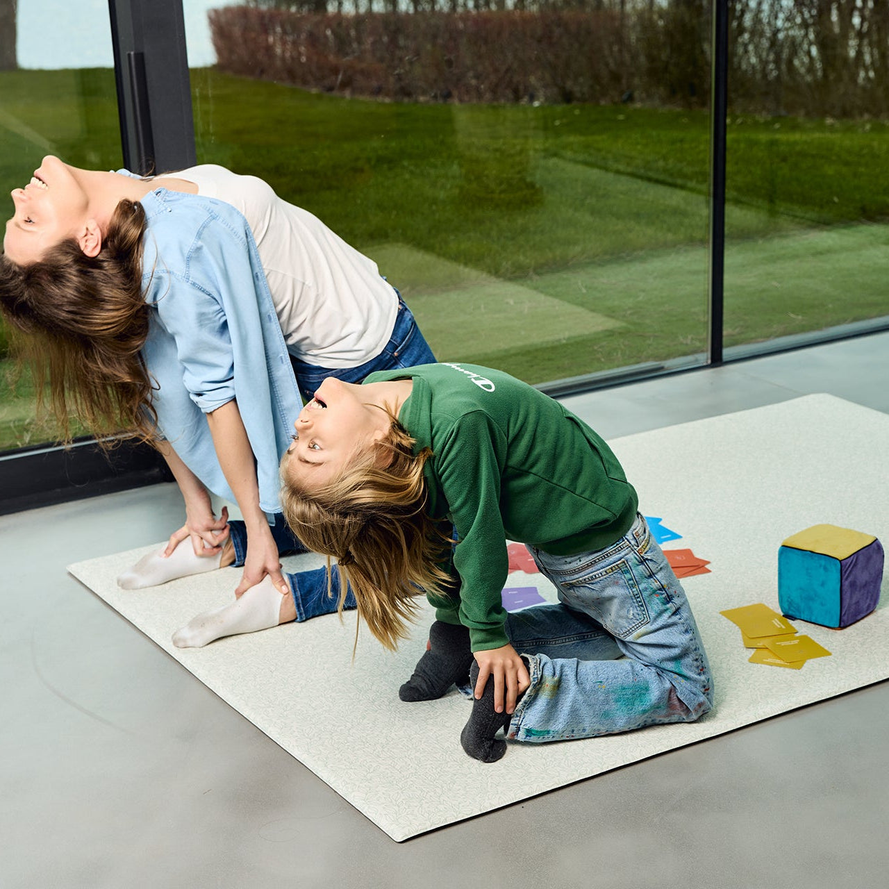 Mama i dziecko wykonują pozycję jogi wielbłąda podczas zabawy z Kostką Aktywności Mindfulness – ćwiczenia ruchowe dla dzieci
