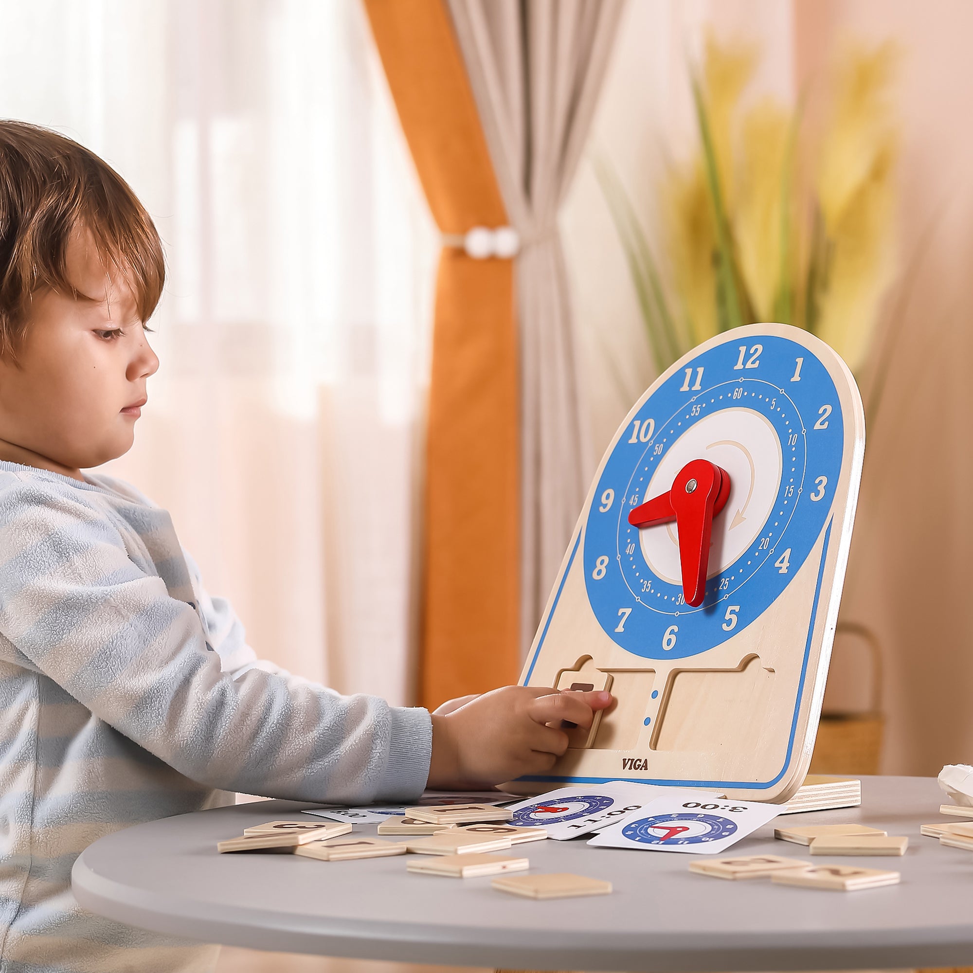 Nauka czasu – dziecko obraca wskazówki drewnianego zegara Montessori VIGA, ucząc się odczytywać godziny i minuty