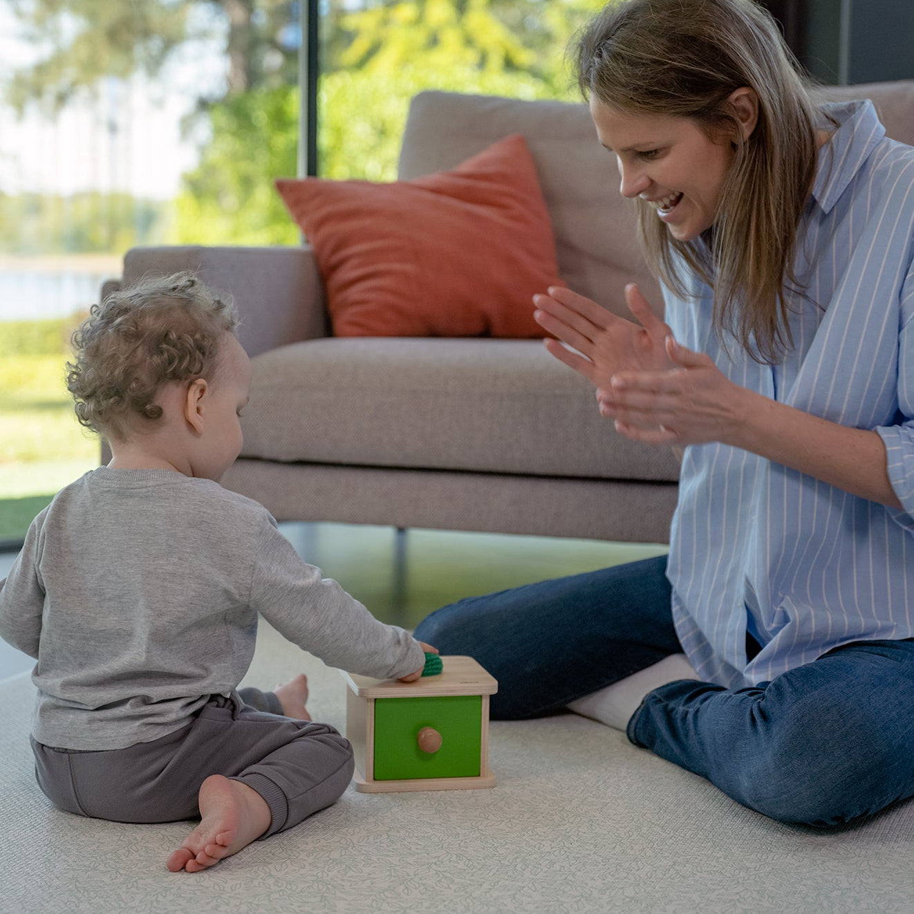 Niemowlę z miękką piłeczką przy szufladce Montessori Educo – chwyt, celowanie i wkładanie do otworu