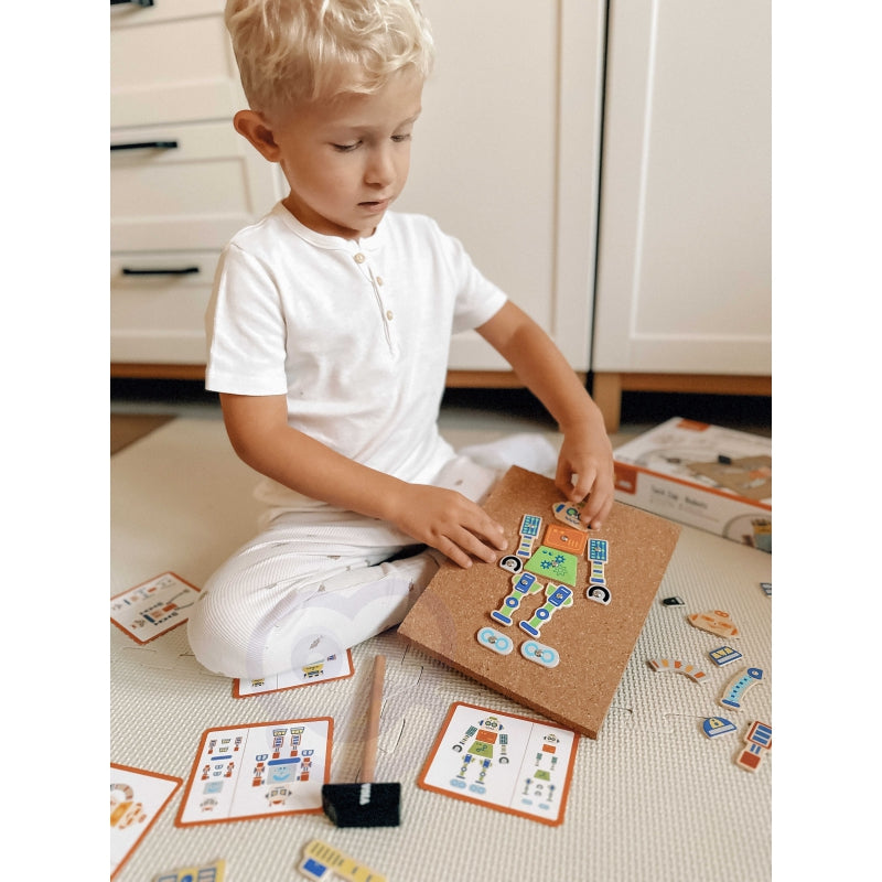 Przybijanie elementów robota na tablicy korkowej VIGA – dziecko ćwiczy precyzję uderzeń młoteczkiem Montessori