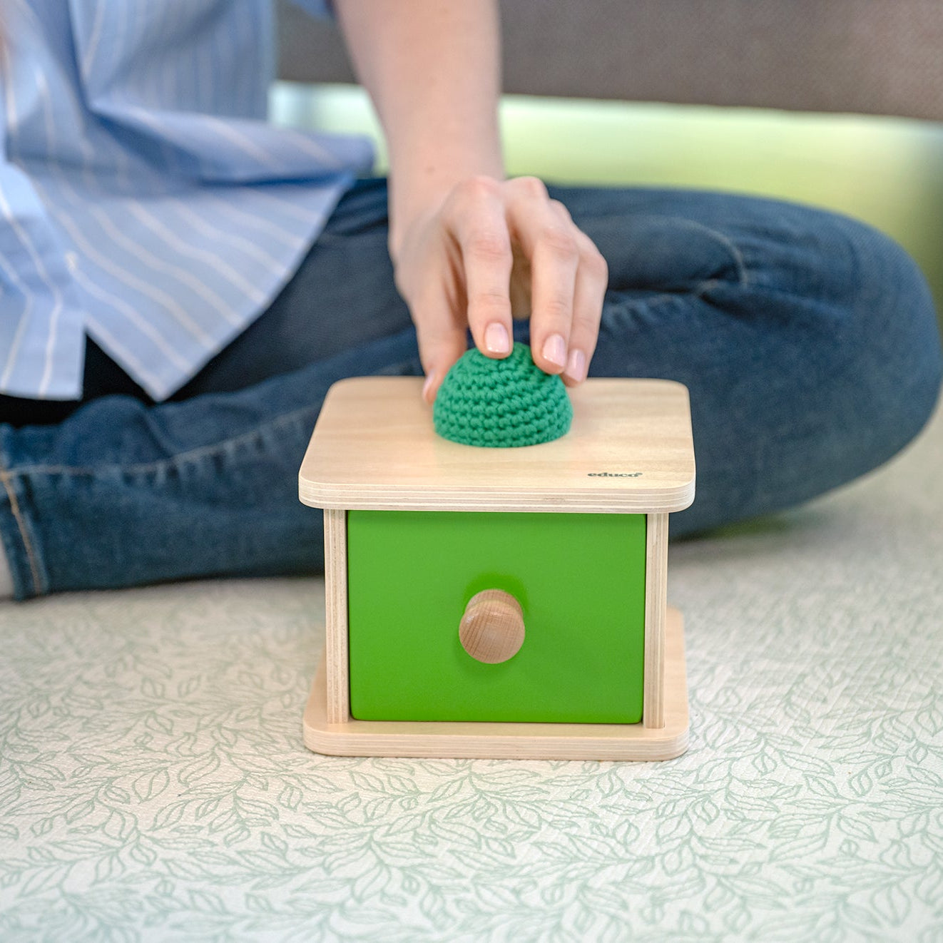 Doświadczenie sensoryczne – kontrast miękkiej piłeczki i drewnianej szufladki Montessori Educo, stymulacja zmysłowa niemowlęcia